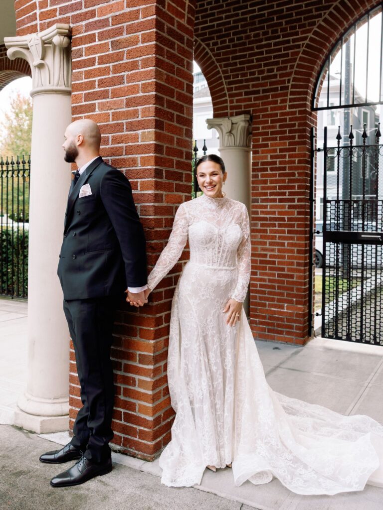 Couple holding hands by brick arches